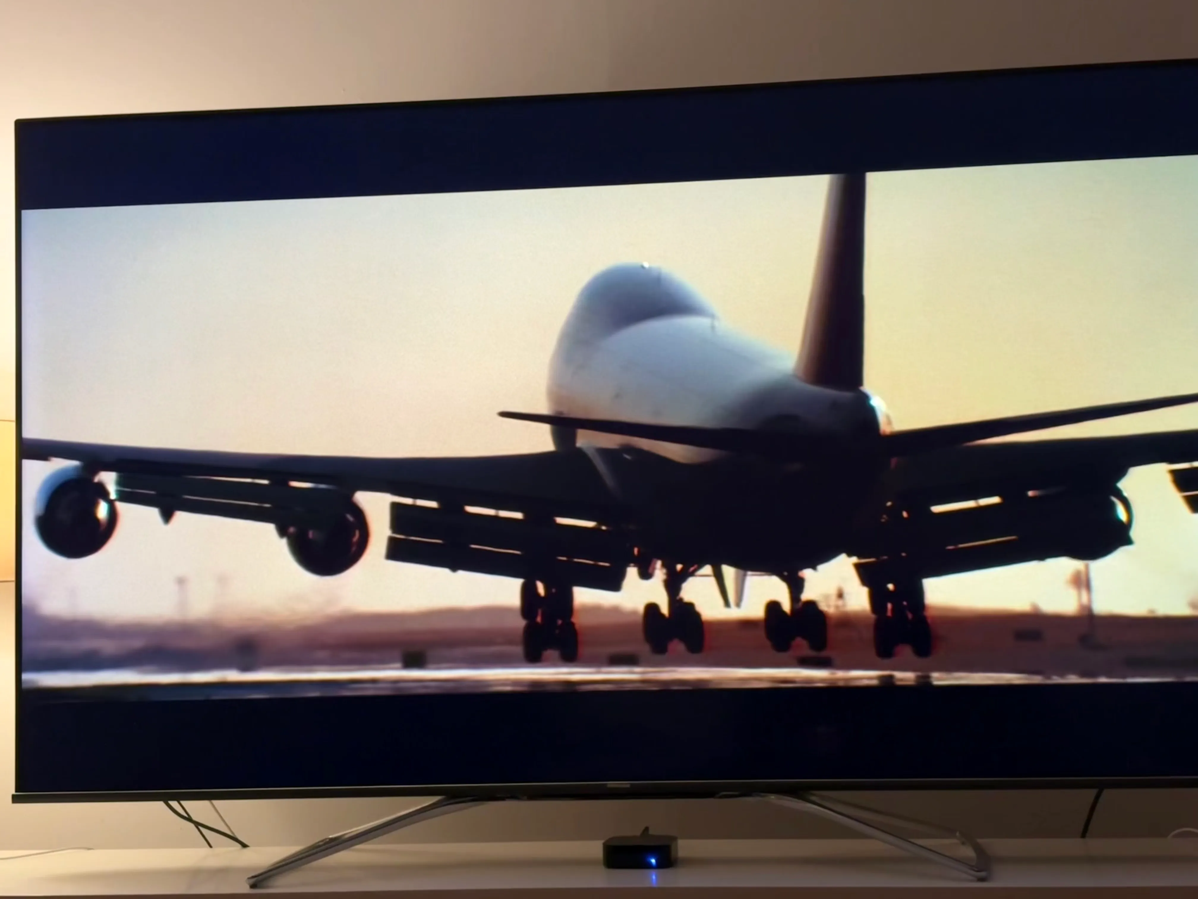 A TV screen shows a 747 landing