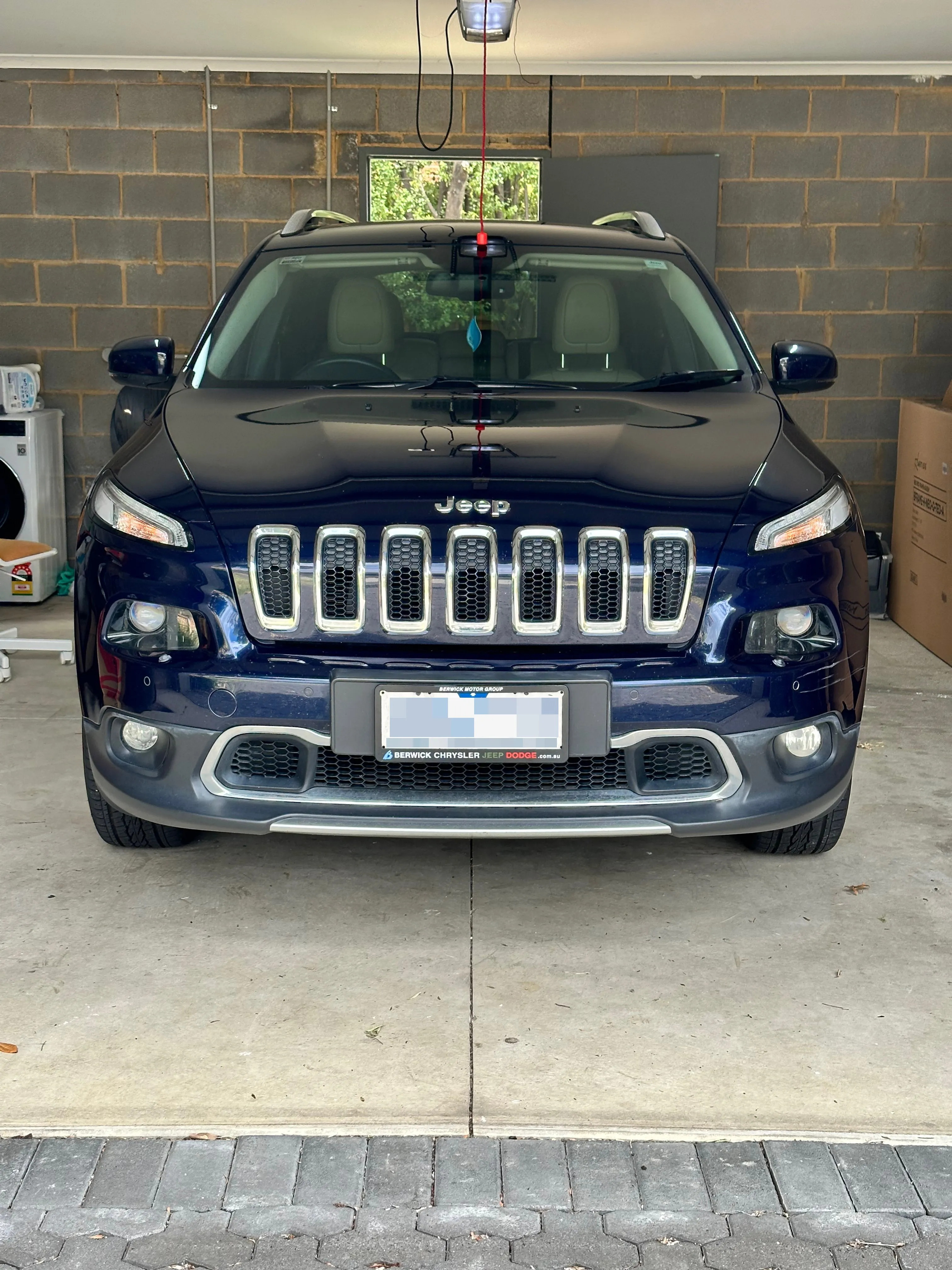 A Jeep Cherokee parked in a garage