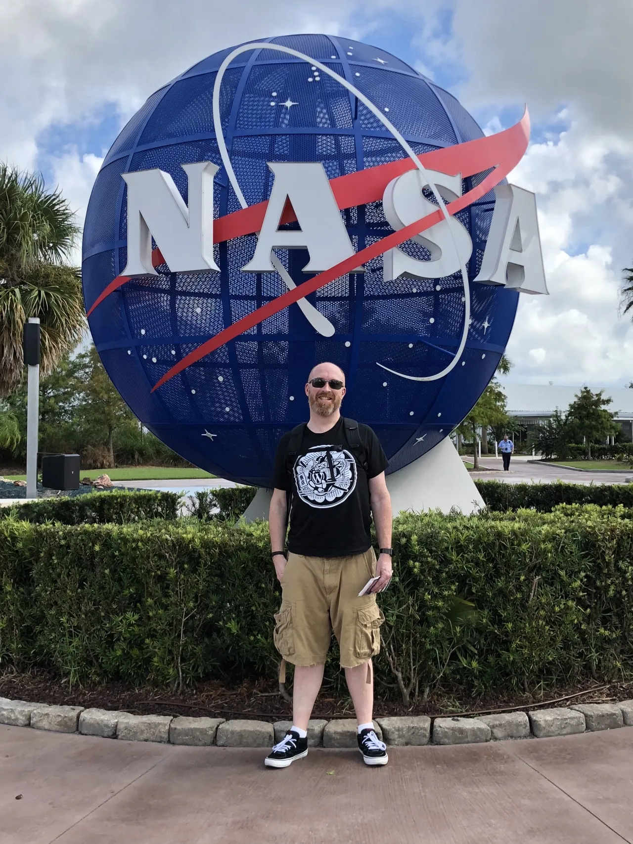 A man standing in front of a NASA globe