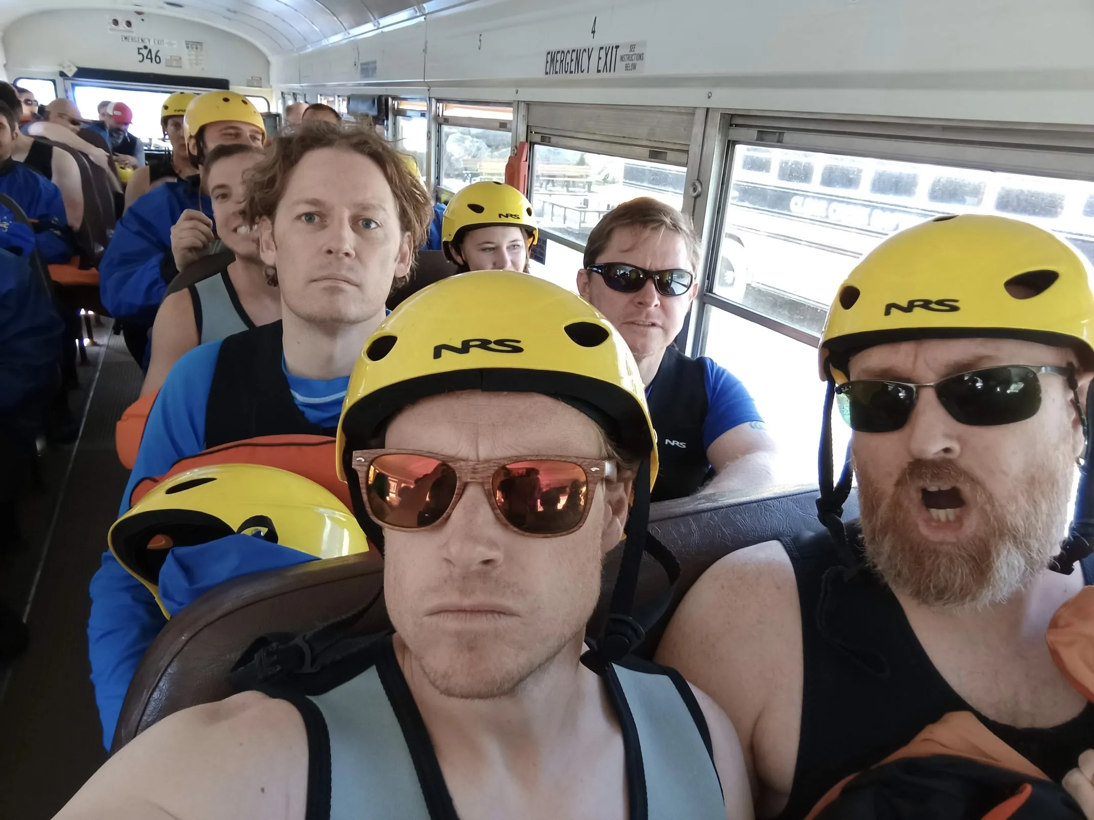 People in helmets and lifejackets on a bus