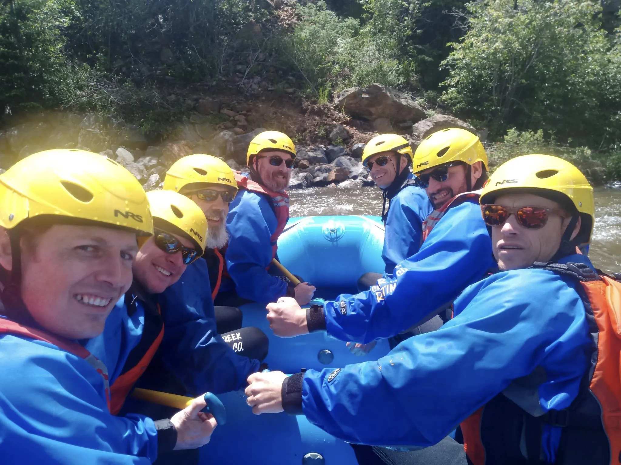 Six men posing on a whitewater raft