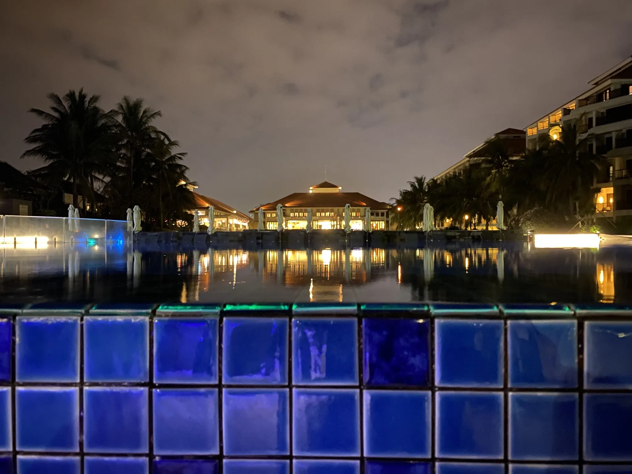 Nighttime photo with lights reflecting on a pool